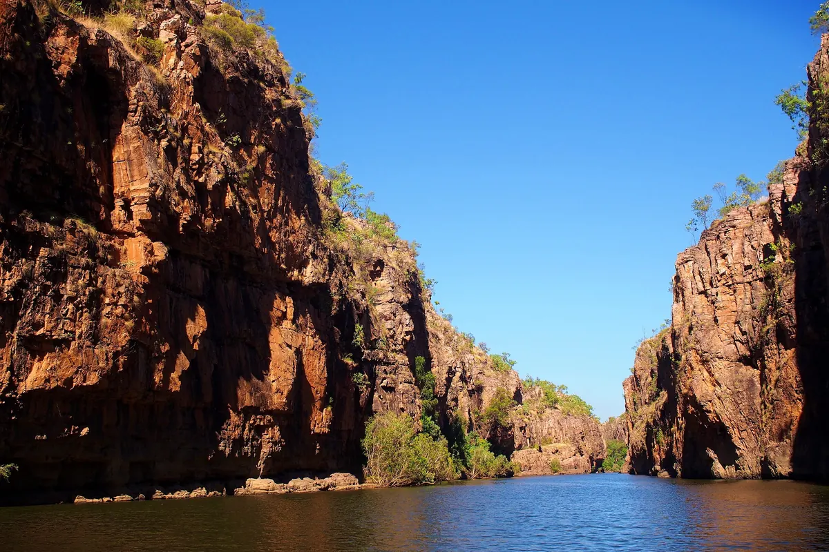 Red sandstone cliffs on both sides of still green water in the first gorge of Nitmiluk National Park (the gorge country near Katherine, not the arena)